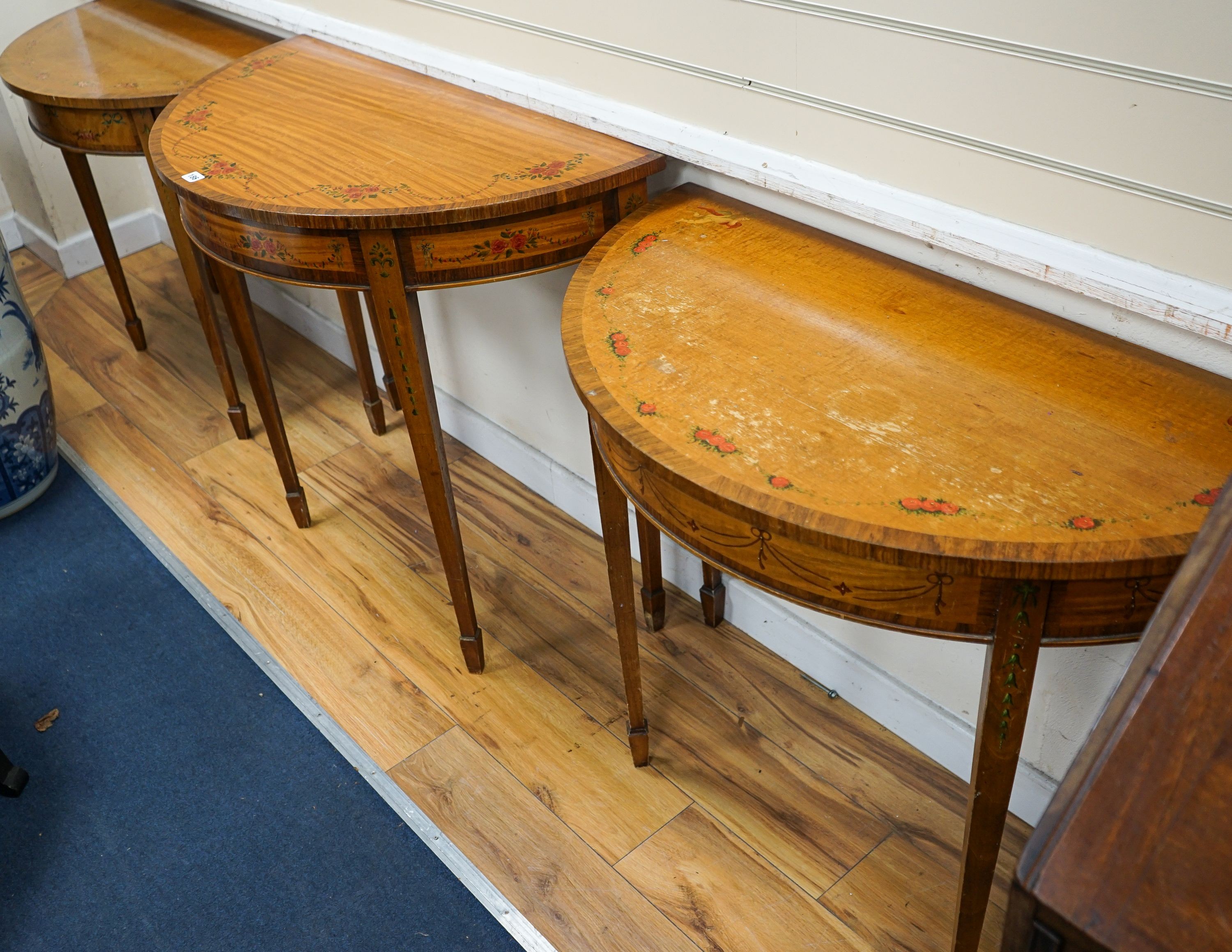 Three Sheraton style painted satinwood demi lune console tables, largest 92cm, width 46cm, height 82cm